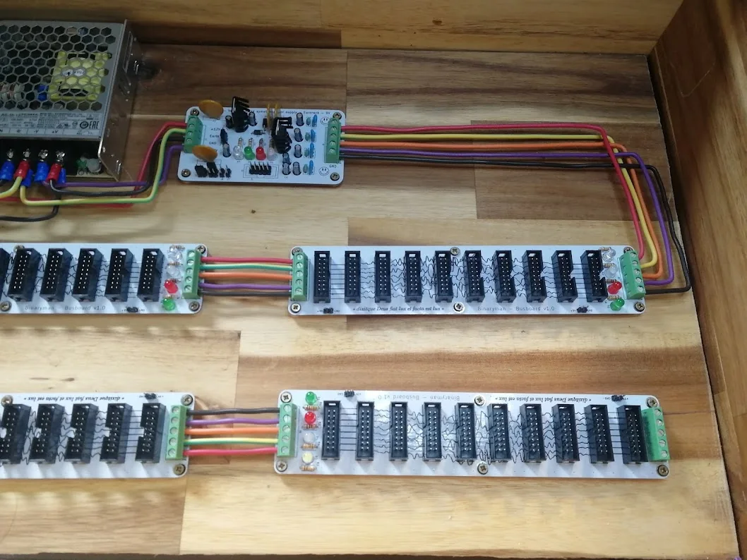 Close-up of coloured wires connecting the supply card and adjacent bus boards through screw terminals.