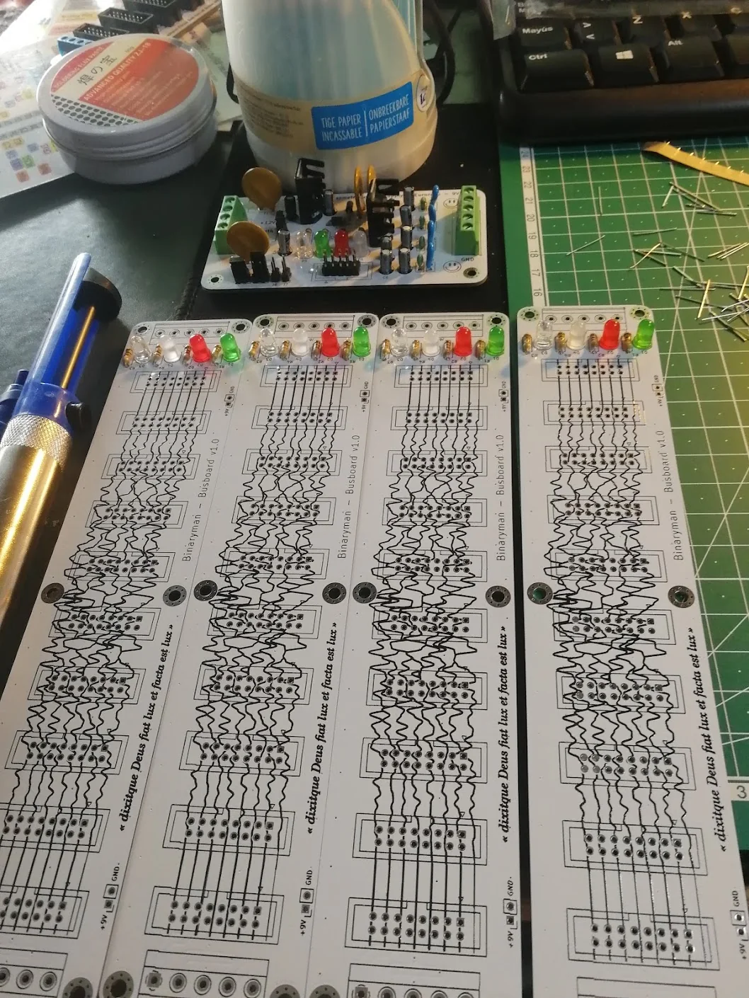Four long bus boards with LEDs and resistors fitted, beside a populated supply card.