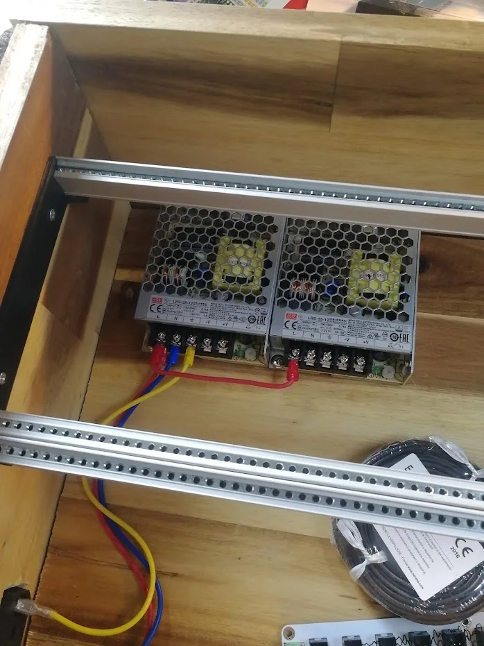 Two Mean Well LRS-35-12 power supplies mounted side by side behind the aluminium rails.