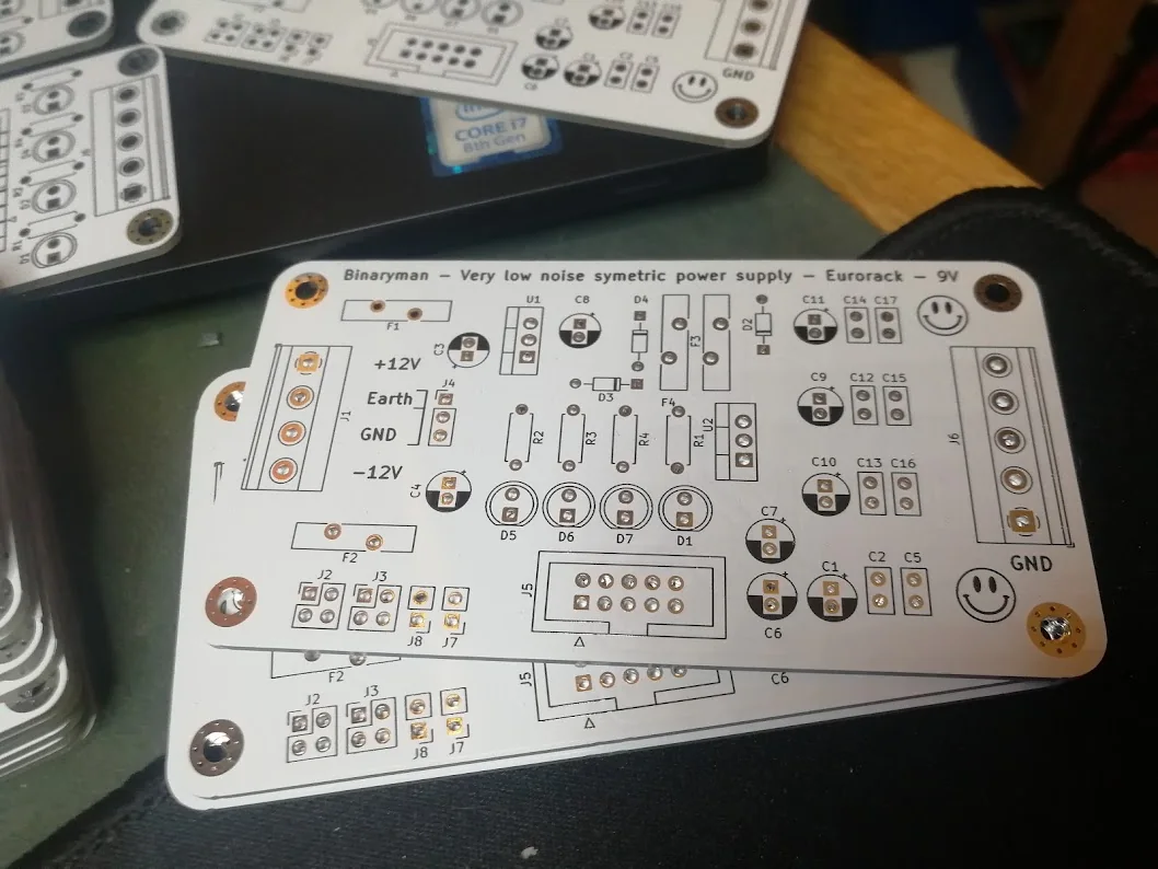 Unpopulated supply PCBs with printed component references and terminal labels.