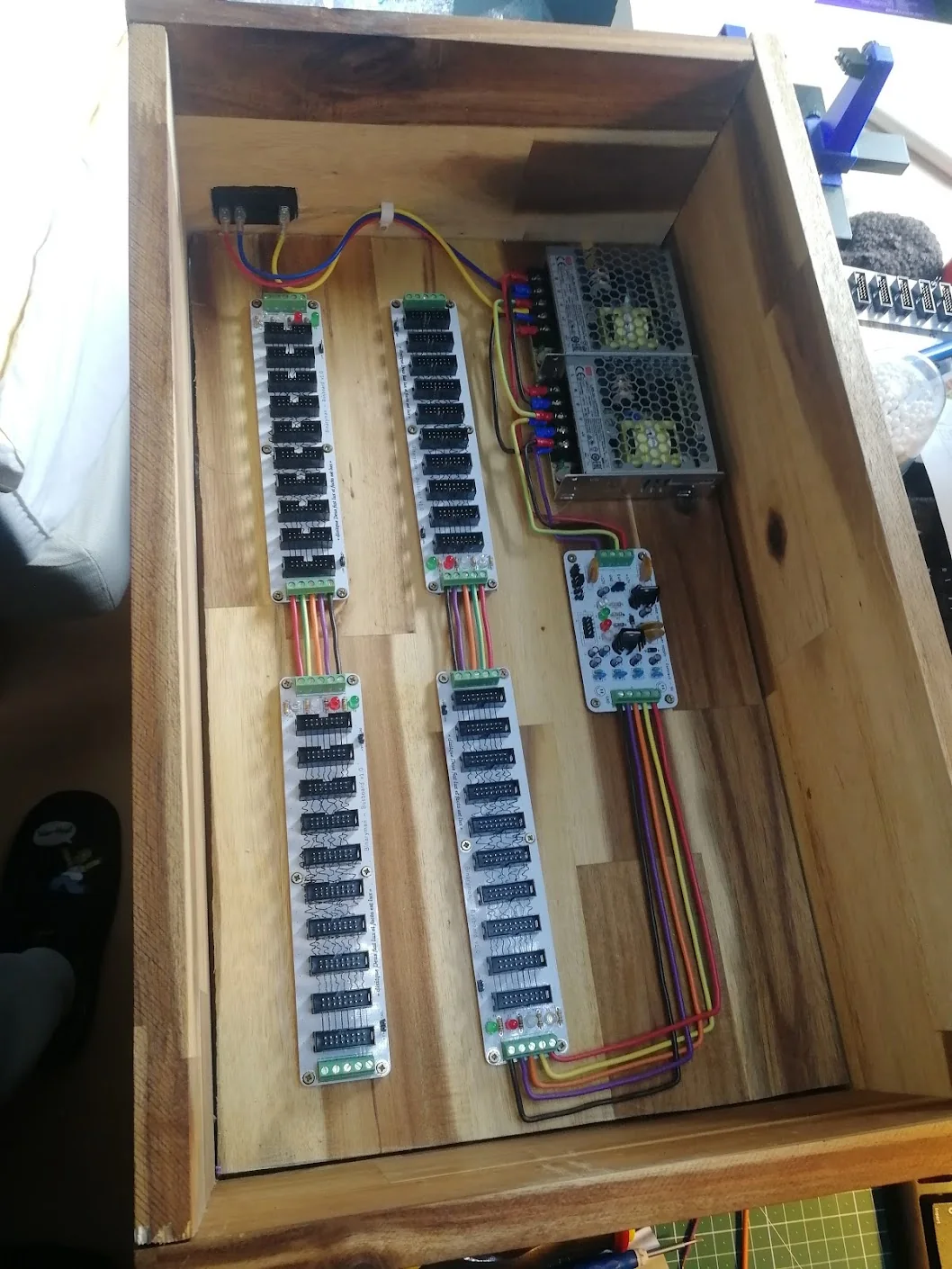 An overhead view into the acacia case showing the two supplies, supply card, four bus boards, and coloured wiring.